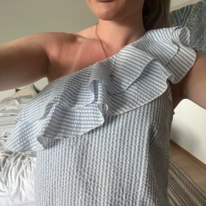 Enaxlad klänning - Säljer denna supersöta klänningen💞 Bandet som man hänger upp klänningen med är av, men det gör ingen skillnad då klänningen är på och går lätt att sy tillbaka❤️ Finns en liten rosa fläck framtill, men inget man lägger mörke till. Buda!