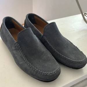 Ljusblåa mocka loafers - Snygga ljusblåa  loafers, Tillverkade i Italien och har en bekväm passform. Läder på insidan, storlek 44, använda endast 1 gång så i princip nya, hör av dig vid frågor!
