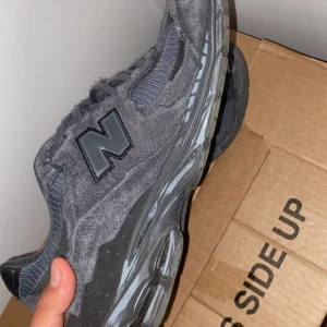 New balance 2002r protection pack - Säljer ett par gråa New Balance sneakers med ovandel i mocka och mesh. Skorna har snörning och en robust sula med bra grepp. Klassisk N-logga på sidan och sportig design som passar till många outfits. Skorna är använda i drygt en vecka och är fortfarande i bra kvalitet. Original box ingår i köpet.