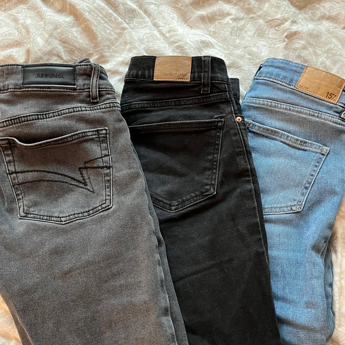 Tre par jeans i olika färger