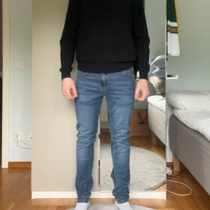 Blå jeansbyxor från Hansen & Jacob - Säljer ett par klassiska blå jeansbyxor från Hansen & Jacob. Byxorna har smal passform, de är av sjuk kvalitet och har snygga detaljer som knappar och dragkedja. Storlek 31/32. Jeasen är sprillans nya, därav nästan nypris.