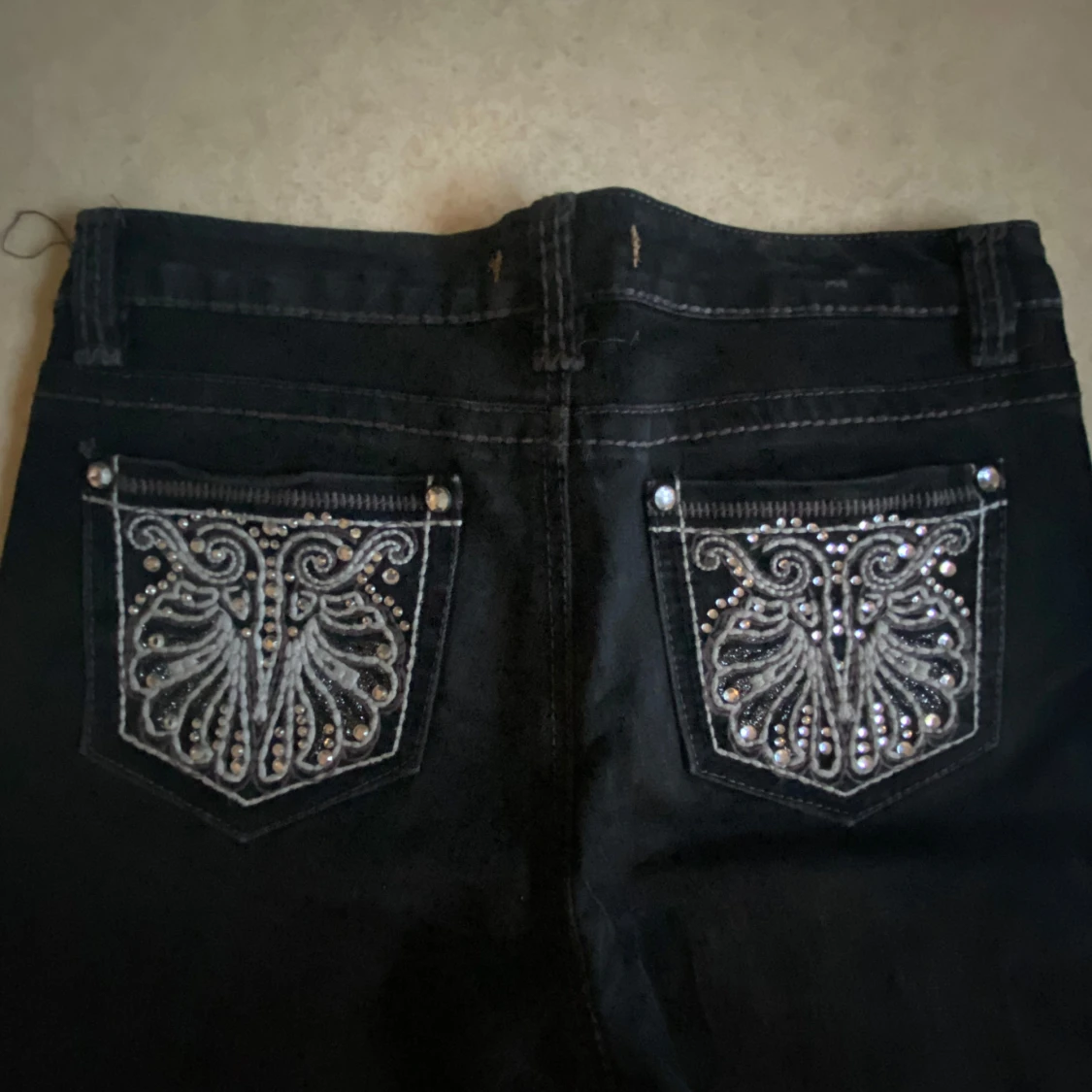 Svarta jeans med broderade bakfickor och strass