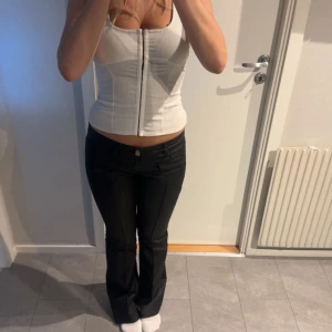 Vit korsett - Snygg vit korsett. Den har en tight passform och breda axelband. Perfekt för att ge en stilren look.