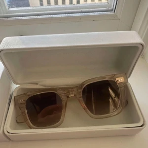 Transparenta solglasögon i fyrkantig design - Snygga solglasögon med transparent båge och fyrkantiga linser. Perfekta för en stilren look. Kommer i ett praktiskt fodral.