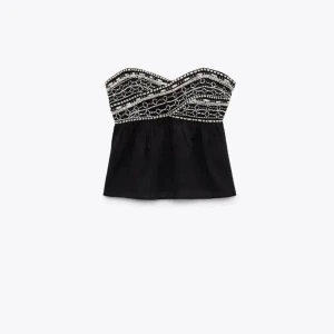Svart bandeau topp med vita pärlor - Säljer denna jättefina bandeau toppen från Zara i storlek S. Den sitter tight vid brösten och tunt tyg ner till som sitter löst. Toppen har också jättefint vitt mönster med pärlor. Pris går att diskutera 