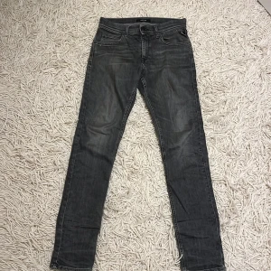 Grå jeans från replay  - Snygga grå jeans från replay modell WALLYS. De har en rak passform och är perfekta för en avslappnad stil. Jeansen har en dragkedja och knapp framtill.