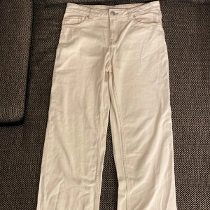 Beige jeans från H&M Divided - Snygga beige byxor från H&M Divided i storlek EU 36/S. Byxorna har en klassisk femficksdesign och stängs med knapp och dragkedja. De har en rak passform och är perfekta för en stilren look. Midjemått: ca 38 cm. Innerbenslängd: ca 78 cm