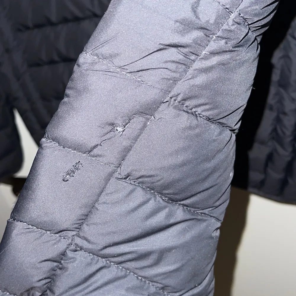 Snygg quiltad jacka från Parajumpers med huva och dragkedja. Litet hål vid ärmen. . Takit.