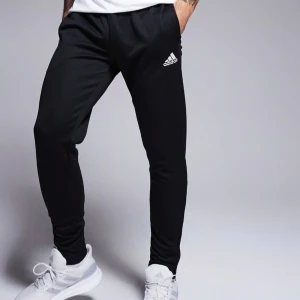 Svarta träningsbyxor från Adidas - Svarta träningsbyxor från Adidas med Climacool-teknologi för optimal ventilation. Byxorna har en elastisk midja och Adidas-logga på benet. Perfekta för träning och vardag.