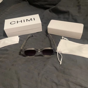 Nya CHIMI 04 grey - Snygga grå solglasögon från CHIMI med transparent båge och mörka linser. Perfekta för en stilren look. Kommer med originalförpackning och fodral. Bara provade allt finns med.