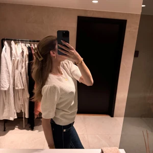 Vit blus med puffärmar - Säljer en söt vit blus med puffärmar. Perfekt för en stilren och elegant look. Blusen har en rund hals och är tillverkad i ett lätt och bekvämt material.