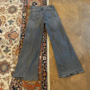 Mother ”the tomcat roller wide leg jeans” grå - Snygga wide leg jeans från Mother. Byxorna har en klassisk femficksdesign och en subtil tvätt för en trendig look.  Byxorna är i mycket bra skick, endast en sliten sömn på ena bakfickan som syns på fjärde bilden. Jeansen köptes 2023.