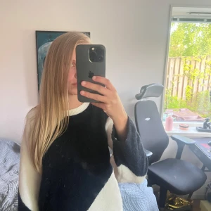 Svartvit stickad tröja med grafiskt mönster - Säljer en stickad tröja i svart och vitt med ett coolt grafiskt mönster. Tröjan har rund halsringning och långa ärmar. Perfekt för dig som gillar en stilren men ändå unik look.