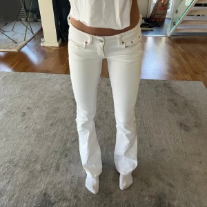Vita Lågmidjade jeans -  ett par vita bootcut jeans med låg midja 