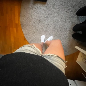 Ljusgrå jeansshorts med fransar - Säljer ett par ljusblå jeansshorts med råa franskantsdetaljer. Klassisk femficksmodell med knapp och dragkedja framtill. Perfekta för varma dagar och enkel att matcha med olika toppar.