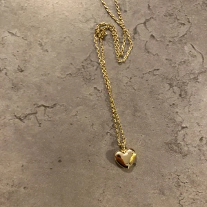Guldigt halsband med hjärthänge - Snyggt halsband i guld med ett litet hjärta som hänge. 
