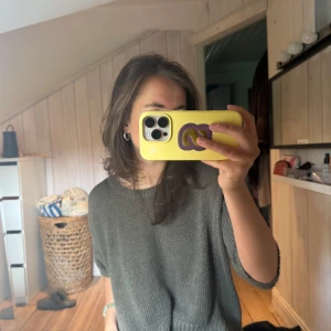 Grå stickad tröja från H&M - Säljer en enkel och stilren grå stickad tröja från H&M BASIC. Tröjan har en avslappnad passform med kortare ärmar och bred ribbad kant nedtill. Perfekt för lager-på-lager och passar till det mesta.