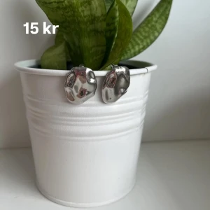 Silvriga örhängen med organisk form - Säljer ett par coola silvriga örhängen med en unik, organisk och lite skulpterad form. Perfekta för dig som gillar minimalistiska men ändå iögonfallande accessoarer. Snygga att matcha med andra smycken!