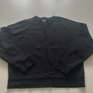 Svart sweatshirt från H&M - En klassisk svart sweatshirt från H&M i storlek XS. Tröjan har rund halsringning, långa ärmar och ribbade muddar vid ärmslut och nederkant. Perfekt basplagg för garderoben. Lite knopprig🖤