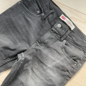 Grå jeansbyxor Levis 512 - Säljer ett par snygga levis jeans som aldrig använts. Storlek 12 (12 år) men funkar för tretton åringar också. Byxorna är i slim taperd. Nypris 600kr