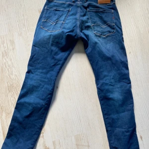 Blå Replay Hyperflex Anbass jeans (Nya) - Säljer ett par blå Replay Hyperflex Anbass jeans. Jeansen har normal passform och är tillverkade i stretchigt material för extra komfort. Strl 32W/30L