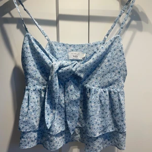 Gullig blå sommartopp med knyte  - En JÄTTEFIN blå blommig topp med knyte, man knyter själv och kan även installera bandens längd💙Den är också urringad. SUPER PASSANDE för sommaren också!!☀️Passar för storlekarna S/XS