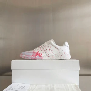 Masion margiela paint splatter - Unika vita sneakers från Masion Martin Margiela med rosa färgstänk över hela skon. Klassisk siluett med rund tå och platt sula. Intressekoll!!! Perfekt för dig som vill sticka ut med en kreativ och modern look. Storlek 44🤩 Allt og ingår‼️