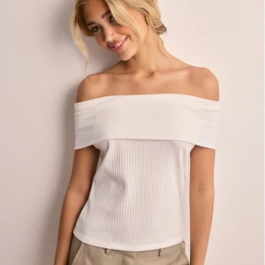 Vit offshoulder ribbad topp - Nelly off shoulder topp. Bilder från hemsidan. De ba fråga så visar jag bilder från verkligheten. Använd 1 gång. 