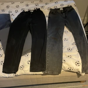 Svarta och grå jeans från Grunt - Två par jeans från Grunt, ett par i svart och ett par i grått. Båda har klassisk femficksdesign och raka ben. Jeansen är tillverkade i ekologiskt material och har knappgylf. Perfekta för en stilren vardagslook. De passar folk som har mellan 170 till s men kan passa vid mindre eller större än så om man vill ha ett par är det bara att skriva. Pris kan diskuteras. 150 kr st 