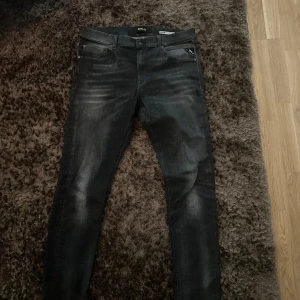 Svarta Replay jeansbyxor herr - Säljer ett par svarta Replay jeans. Byxorna har normal passform och raka ben, med Replay-logga på fickan och bak på linningen. Perfekta för dig som gillar stilrena jeans.