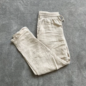 Beiga linnebyxor - Säljer ett par sköna, beiga linnebyxor i strl XS! Skick 9/10, inga tecken på användning. Hör gärna av er!