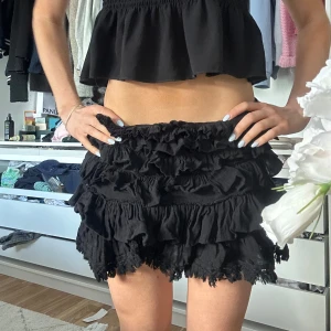 Svart volangkjol från Anine Bing - Supersöt och unik svart kortkjol från Anine Bing med flera lager volanger. Kjolen har en dragkedja, knappt använd!!