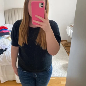 Marinblå stickad kortärmad tröja - Marinblå stickad tröja med korta ärmar och rund halsringning. Modellen är lite loose och passar perfekt till jeans eller kjol. Mjuk och skön känsla, enkel att styla för en chill look. Den är lite nopprig (se bild 3)