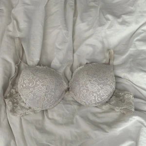 Vit spets-bh push up C75 - Säljer en vit push up-bh från Cubus  i storlek C75. Bh:n har vacker spets med blommigt mönster, Axelbanden är justerbara 