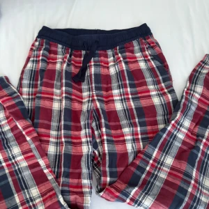 Rödblå rutiga mjukisbyxor Kappahl - Rutiga mjukisbyxor från Kappahl i storlek 146/152. Byxorna har en skön elastisk midja med snörning och är gjorda i mjukt bomullstyg. Färgerna är röd, blå och vit, och mönstret är klassiskt rutig. Perfekta för chill hemma eller häng med kompisar.