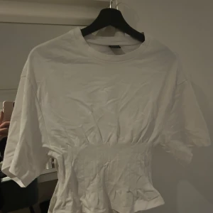 Vit T-shirt med tight midja/ ribbad midja  - En super fin vit t - shirt ifrån Gina Tricot med tight/ ribbad midja. Perfekt till både skola med också fest! Säljer då jag rensar min garderob och känner inte att jag använder den !! 🥰