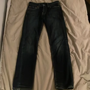 Levi's 511 premium mörkblå jeans slim fit - Säljer ett par klassiska Levi's 501 jeans i mörkblå tvätt med en slim fit. Ikonisk läderpatch bak och röda Levi's-tag på bakfickan. Jeansen är väl omhändertagna och användts fåtal gånger. Nypris cirka 1500. Hör gärna av om det är något