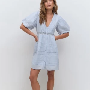 Ljusblå kort klänning med spetsdetaljer - Supersöt ljusblå klänning från Gina Tricot med v-ringning, puffiga korta ärmar och spetsdetaljer vid midjan och på kjolen. Knäppning framtill och luftig passform som ger en chill vibe. Perfekt för varma dagar och har en romantisk look. Den är i bra skick och bara använd en gång. Säljer då jag känner att jag inte har nytta av den! 