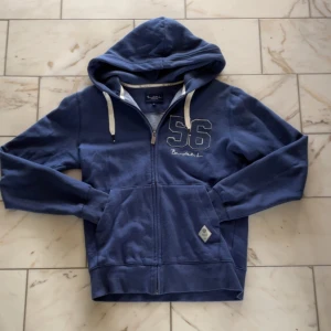 Blå hoodie från Bondelid med dragkedja - Chill marinblå hoodie från Bondelid med broderad 56 på bröstet. Plagget har inga defekter och i mycket skönt material. Passar som storleken. Hör av dig vid eventuella frågor!🙌