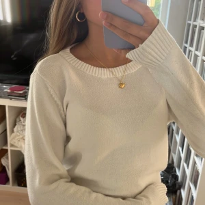 Vit stickad tröja från VILA - En enkel och stilren vit stickad tröja från VILA med rund hals och ribbade muddar vid ärmslut och nederkant. Tröjan har ett litet hål på baksida ärm (som man ser på bilden)