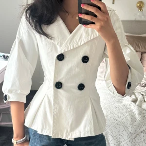 Kappa med trekvartsärm - Hej!! Jag säljer denna jättesöta kappan med trekvartsärm som är köpt utomlands. Storleken är M men jag som brukar ha xs har målat in den från insidan med en säkerhetsnål som enkelt går att ta bort om man skulle vilja (har den i på alla bilder). Tveka inte på att skriva vid frågor och pris kan diskuteras!🤗