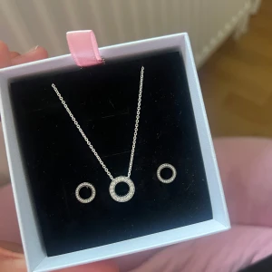 Pandora smyckesset - Säljer ett jättefint set från Pandora med halsband och matchande örhängen i äkta sterlingsilver, aldrig använts! Settet säljs inte längre på pandoras svenska hemsida, men finns på den amerikanska där det säljs med nypris 165 dollar / 1600kr. Pris kan absolut diskuteras, vill bara bli av med det 🩷🩷🩷