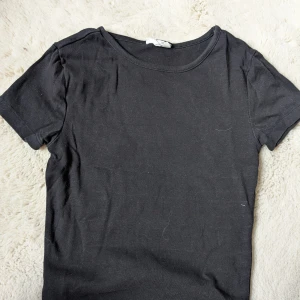 Kort tajt svart tshirt - Den e något croppad och har en tajt passform