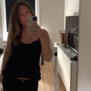 Svart linnetopp med knyt från Zara - Supersnygg svart linnetopp från Zara med tunna axelband som knyts på axlarna. Perfekt att styla med jeans eller kjol. Toppen är liten i storleken och har använts två gånger🩷