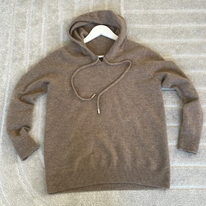 Beige stickad hoodie - Säljer en mysig beige stickad hoodie med långa ärmar och justerbar dragsko i huvan. Perfekt för kyliga dagar. 🧥| Med ett hål vid vänster armhål,( som är fixat)