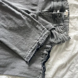 Ljusgråa low waist bootcut jeans - Säljer ett bar skitsnygga lågmidjade bootcut jeans då de är lite för korta på mig, har en snygg stjärna på ena bakfickan och har sprätt upp byxorna nera vit fötterna så de blor någon centimeter längre, passar 160 jättebra 