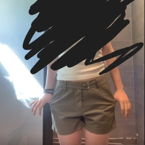 Olivgröna shorts med fickor - Snygga olivgröna shorts med normal passform och midwaist. De har praktiska sidfickor, bälteshällor och stängs med knapp och dragkedja. Perfekta för varma dagar och enkel att matcha med olika toppar. Säljer då de inte används längre.