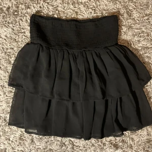Svart volangkjol med resårmidja - Supersöt svart kortkjol med bred resår i midjan och dubbla volanger. Den är i storlek 158-164, men den passar även xs-s. Även väldigt fin som topp. 💗