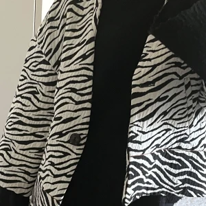 Zebramönstrad jacka från Zara - Säljer en riktigt cool zebramönstrad jacka från Zara. Jackan är svartvit med breda trekvartsärmar, knäppning framtill och croppad passform. Perfekt statement-plagg för dig som vill sticka ut. 💕