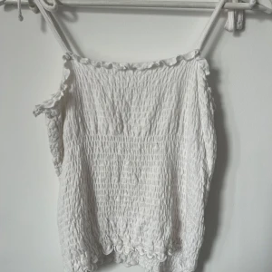 Linne - Vitt linne med knytning vid axlarna, väldigt stretchig så den passar allt från S till L.